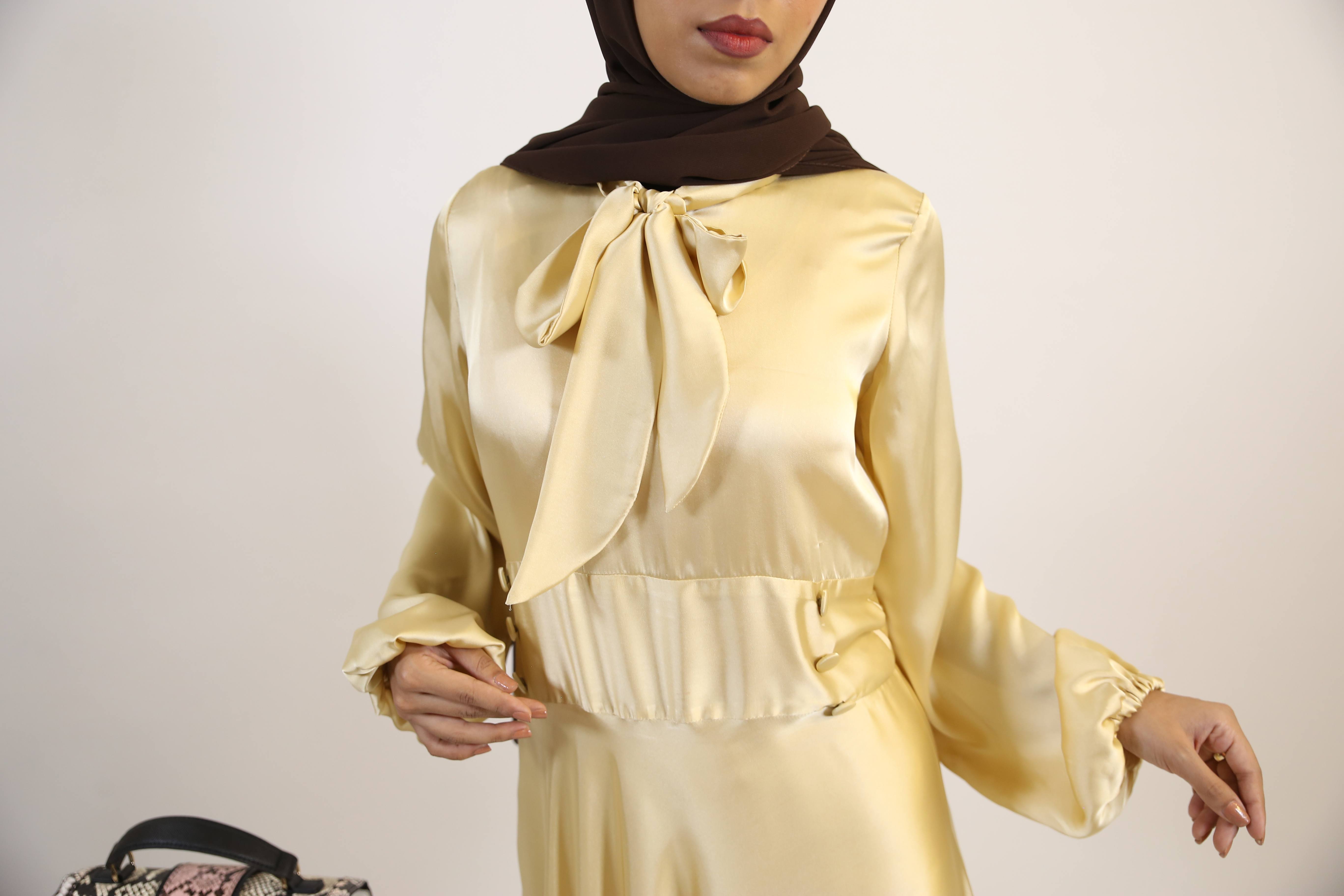 Aqeeq- Glamorous Satin Maxi dress with bow neck and waist button detailing- Pastel Yellow