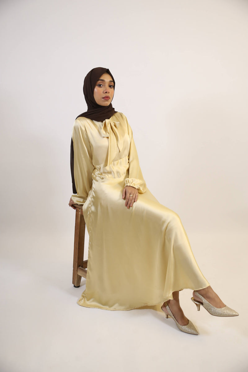 Aqeeq- Glamorous Satin Maxi dress with bow neck and waist button detailing- Pastel Yellow